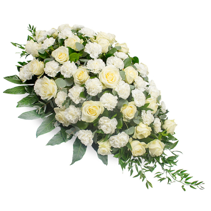 This image presents a refined white funeral spray arranged in an elongated teardrop form, set against a pure, uncluttered white background that keeps every detail of the flowers in clear focus. The spray is fullest at the upper left, where a generous cluster of white and soft cream roses is gathered closely together. Some of the roses are tight buds, promising bloom, while others are fully open, revealing layered, velvety petals spiralling from the center in gentle curves. Between these classic blooms sit frilly white carnations, their many ruffled petals adding depth and a cushion-like softness that makes the composition feel both abundant and tender. Supporting this cloud of blossoms is an underlay of varied greenery: broad leaves in deep green provide structure, while muted silvery eucalyptus foliage weaves throughout, introducing a cool, refined tone. From the lower right of the spray, slender stems of ruscus or similar trailing greenery extend outward, creating a flowing, tapering tail that accentuates the crescent silhouette. The effect is calm and contemplative, like a moment of stillness away from the usual energy of Clerkenwell Green or nearby Smithfield. This type of sympathy arrangement is typically used as a casket spray or placed beside a coffin at a funeral, wake, or memorial service, offering a visual message of peace, respect, and remembrance. The white palette suggests innocence and serenity, while the careful balance of texture and form reflects the experienced hand of a local florist who understands both the craft of design and the sensitivity required during times of loss.
