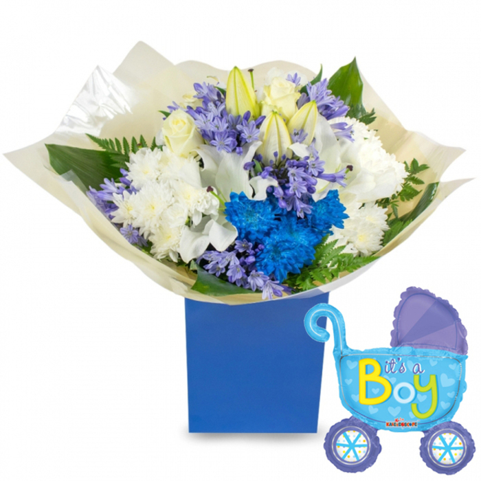 An elegant, celebratory newborn bouquet arranged in a deep royal-blue rectangular box, crafted to greet a new baby boy with classic whites and bold blue accents. The central arrangement features creamy white roses and slender white lilies, some just beginning to open so they embody newness, while generous white chrysanthemums offer plush texture and a soft, voluminous foundation. Against this serene base, vibrant electric-blue chrysanthemums provide dramatic, joyous pops of colour, complemented by clusters of pale lavender or periwinkle, hyacinth-like blooms that introduce a refined, peppered texture. Sprays of fresh foliage-broad, glossy leaves and airy fern fronds-frame the blooms and add depth, their green tones lifting the cooler palette. The bouquet is wrapped in a crinkled, translucent cream paper gathered at the base, the slight rustle of the material suggesting careful, hand-finished presentation. To the right, a light-blue foil balloon shaped like an old-fashioned baby pram floats, detailed with darker blue canopy and wheels, tiny hearts and polka dots, and the cheerful message It's a Boy printed in bright yellow-green letters across the carriage. The lighting is soft and natural, as if photographed in the calm mornings of Clerkenwell near Leather Lane; you can almost sense the faint green fragrance of stems and the tactile contrast between silky petals and the crisp box. This combination reads as a considered, joyful gift for a hospital bedside, a baby shower, or a welcome-home visit within the local neighbourhood.