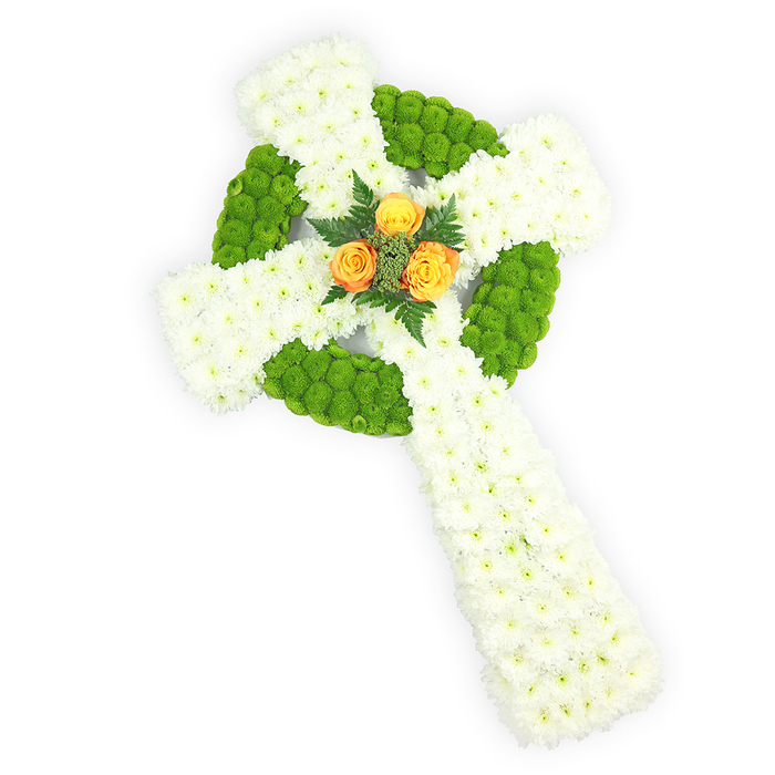 A meticulously shaped floral Celtic cross rests against a pure white background, photographed from a slightly elevated viewpoint to showcase its three-dimensional presence. The cross's framework is assembled from dense clusters of small white spray chrysanthemums, arranged to form plush, seamless arms and a dignified lower shaft; their compact heads create an impression of softness and unwavering calm. Interlaced through the white are bright lime-apple green button chrysanthemums, positioned with deliberate rhythm to sculpt the circular ring where the arms meet and to punctuate alternating panels along each arm-this green embroidery lends the cross a lively definition and almost knot-like Celtic geometry. Anchoring the design at its center are three vivid orange-yellow roses, fully open and glowing like a gentle ember against the cooler tones; these roses are framed by deep green fern sprigs that heighten the centre's depth and provide a natural contrast to the crisp florals. The lighting is gentle and revealing, bringing out the velvety texture of the rose petals and the fine, downy feel of the chrysanthemums while the stark white backdrop isolates the symbol for contemplative focus. For families who have asked for a memorial that honours Irish identity or St Patrick's Day connections, this arrangement resonates-its white, green and orange echo the Irish flag in a refined, respectful manner. Created for use as a funeral tribute, remembrance cross, or sympathy offering, this piece reads as both a statement of faith and a personal, handcrafted farewell, suitable for services around Clerkenwell, Smithfield Market, or nearby Spa Fields.
