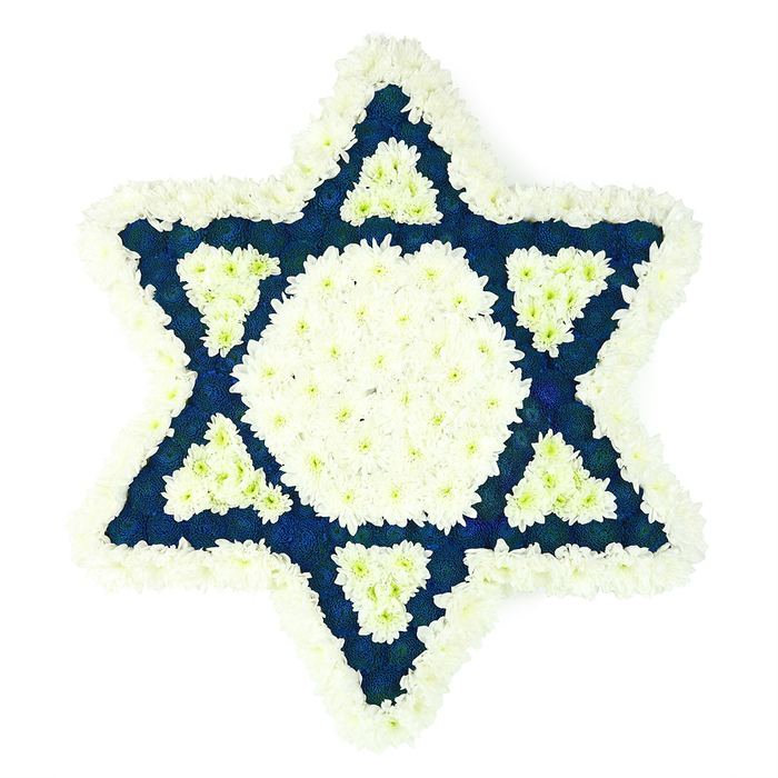 This image presents a large Star of David funeral tribute, laid out against a bright white background so that every curve and point of the floral work is clearly visible and easy to trace in the mind's eye. The entire Magen David is constructed from masses of small, fresh flowers in only two tones-pristine white and a saturated dark blue-chosen for their ability to hold shape and colour throughout a long service or shiva visit. A generous outer band of fluffy white blooms, likely spray chrysanthemums or similar, forms a soft, pillowed edge to the star, outlining the sacred symbol with a sense of tenderness and care. Within this cushion of white, the central area of the star is defined by a large, pure white hexagon, tightly packed so that no gaps or greenery show through, suggesting a steady, luminous centre of memory. From this core extend six triangular limbs made entirely of navy or indigo blossoms, whose depth of colour recalls the blue of traditional tallit stripes or the flags often seen during Jewish celebrations in Clerkenwell and beyond. Each blue arm holds a smaller white triangle set near its base, an intentional detail that adds pattern, meaning, and visual clarity. The arrangement gives a feeling of quiet order and dignity, as if each petal has been handled with reverence by local florists familiar with Jewish customs and the sensitivities of mourning. Whether delivered to a synagogue near Farringdon, a funeral home on a side street off Clerkenwell Green, or a family residence, this floral Star of David offers a composed, respectful farewell, expressing love, faith, and a lasting connection to community.