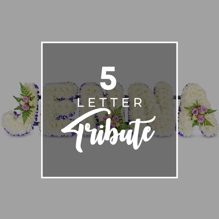 The photograph captures a lovingly constructed five-letter funeral flower tribute, presented in a modern, uncluttered style that would feel at home in a Clerkenwell memorial service or crematorium chapel. Set against a smooth, pale grey backdrop, the letters lie in a neat horizontal line, their forms solid and clearly shaped. Each letter is built from a dense bed of white chrysanthemums, their tightly packed heads forming a soft, velvety surface with tiny shadows between the petals that add depth and dimension. Along the outer edges runs a continuous border of deep purple satin ribbon, carefully folded and pinned so that its glossy finish frames the white blooms with a refined, respectful contrast. Here and there, small groupings of accent flowers decorate the base: pale pink and lilac-mauve spray roses with gently curved petals, partnered with lacy green fern fronds and a few sprigs of fresh foliage that spill slightly over the edges of the letters. These clusters introduce just enough colour to suggest warmth and affection without overpowering the serene white foundation. Over the middle portion of the arrangement, a semi-transparent grey square overlay appears, edged with a white frame. On this overlay, the words 5 LETTER are written in white uppercase sans-serif type, stacked above the word Tribute in an elegant, cursive script. Behind the overlay, the shapes of individual characters - including what seems to be J, O, H, N and A - are partially visible, hinting at how a loved one's name might be spelled out. The overall mood is one of quiet dignity and personal remembrance, reflecting the kind of bespoke work a skilled Clerkenwell florist designs for final goodbyes.