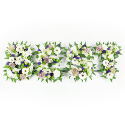 An intimate, three-letter floral tribute spells out DAD in a soft tapestry of whites, purples, and fresh greens, photographed against a pristine white backdrop to emphasise clarity and calm. Each letter is densely packed with velvety chrysanthemums and large ivory gerbera heads that bring a gentle, open face to the design; interspersed are pastel coffee-hued roses whose subtle warmth grounds the arrangement and introduces a quiet dignity. Small clusters of violet statice and deeper purple filler blooms pepper the composition, creating thoughtful accents that read like quiet, sympathetic notes. The letters are edged with lively fern fronds whose crisp, serrated outlines frame the petals and give the whole piece an elegant, breathing border. Within the letters, compact green button chrysanthemums and tight foliage clusters add depth and a tactile, almost cushion-like texture beneath softer petals. A dark grey structural backing is partially visible in places, lending architectural clarity so each letter retains clean definition from above. The image conveys more than form: it carries scent-the faint sweetness of roses and the green, earthy perfume of ferns-and the sensation of careful hands arranging each stem with respect. Created in a Clerkenwell studio close to Leather Lane and Farringdon, this style of tribute is commonly chosen for funerals or memorial services where families want a personal, lettered expression of grief and love. Clerkenwell Flowers can prepare and deliver similar bespoke tributes locally; the arrangement's overall mood is one of quiet remembrance, tactile comfort, and heartfelt ceremony.