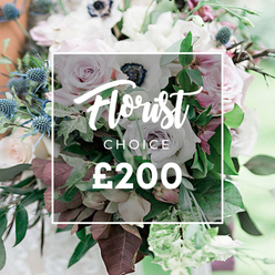 Elegantly staged by Clerkenwell Flowers, this Florist CHOICE ?200 bouquet sits at the heart of a softly blurred scene, the white overlay framing Florist CHOICE ?200 in refined script. The palette blends creamy whites, pale pinks, and muted lavender tones, exuding luxury and thoughtful curation. The stars of the arrangement are light pink garden roses in generous, open blooms; white anemones with their inky centers provide a piercing focal point; and delicate purple-grey roses lend a contemporary depth. A row of blue eryngium thistles introduces crisp architectural contrast, their spiky silhouettes balancing the bouquet's gentle curves. The greenery is abundant and varied, with eucalyptus-like leaves adding a silver-green sheen and deeper burgundy foliage grounding the design. The composition feels both lush and calm, as if grown in a private garden near Farringdon's lanes or Exmouth Market's artful shops. It is clearly a bespoke offering, priced at ?200, perfect for weddings, anniversaries, or a refined gift that speaks of craft and locality. Clerkenwell Flowers emphasizes fresh, seasonal blooms and skilled assembly, with options for same-day delivery across Clerkenwell, Barbican, and neighbouring districts, ensuring the bouquet arrives in pristine condition to celebrate a milestone or convey heartfelt congratulations.