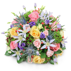 A round, lavish bouquet sits against a pure white background, the simplicity of the setting drawing attention to the intricate floristry and layered textures of the flowers. At first glance, clusters of garden roses in soft pink, warming yellow, and creamy peach create a plush, cloud-like dome, their ruffled petals opening in delicate spirals. Tucked among them, pale lavender and white clematis stretch out star-shaped petals, each centered with a sunburst of yellow stamens that brings a touch of light and movement. Rising through the softer blooms are distinctive blue eryngium, the sea holly's spiky, steel-blue heads adding an unexpected, contemporary edge, almost like a piece of modern sculpture displayed in one of Clerkenwell's gallery spaces. Deeper notes of colour appear in the form of rich purple lisianthus, some still in tight, promising buds, others gently unfolding, contributing a velvety contrast. Dotted between the petals are clusters of glossy red hypericum berries, their rounded shapes echoing the fullness of the bouquet while adding a cheerful, almost festive accent. The entire arrangement is cradled by a tapestry of foliage: broad, polished green leaves; finer, fern-like greens; and subtle hints of dark, wine-toned foliage that give the bouquet depth and shadow. The composition suggests a bouquet carefully crafted for a celebration in a Clerkenwell loft or a special delivery to an office near Farringdon, radiating joy, gratitude, or quiet romance. Every element feels intentionally placed, reflecting the eye and touch of a skilled local florist used to creating designs that feel both luxurious and naturally gathered.