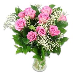 A classic glass vase holds a tightly composed bouquet of pink roses and white baby's breath, presented against a spotless white background that allows every detail of the arrangement to be clearly seen. Around a dozen roses form the heart of the design, their petals unfolding from gentle blush to richer pink, capturing that soft, affectionate mood people in Clerkenwell often choose for baby celebrations and naming days. Some roses are more open, displaying intricate whorls at their centres, while others remain slightly closed, giving a sense of freshness and continuity, like the early days of a new family. Fine sprays of Gypsophila weave between the blooms, with dozens of teeny white blossoms creating a feather-light canopy that wraps the roses in a halo of purity and innocence. Dark green leaves nestle around and beneath the flowers, substantial and glossy, grounding the airy whites and pinks with a deep, natural contrast that adds depth when viewed from across a room. The transparent vase shows the stems gathered neatly in clear water, a small but reassuring sign of just-cut quality from a florist familiar with local homes and apartments around Clerkenwell Green and Farringdon Road. The lighting is bright yet gentle, with no harsh shadows, allowing the viewer to almost feel the velvety texture of the petals and the faint coolness of the glass. Overall, this arrangement communicates quiet joy and tenderness, ideal for welcoming a newborn, sending thoughtful congratulations to parents near St John Street, or adding a serene, celebratory touch to a baby shower in a Clerkenwell studio.