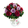 A lush, hand-arranged bouquet of deep crimson and soft lavender roses, densely gathered into a rounded, painterly dome that feels both romantic and quietly joyful. The roses are fully open, their velvety petals unfurling in layered spirals: the reds range from rich burgundy to true crimson, while the purples sit in the gentlest lilac and dusty mauve tones. Nestled among the blooms are small clusters of bright red-orange rose hips that catch the eye like cheerful punctuation, their glossy skins and knobbly textures offering a contrast to the satiny softness of the petals. Dark green foliage - likely Ruscus or Salal - threads through the arrangement, its matte, elongated leaves creating depth, framing each bloom, and giving the bouquet a fresh, garden-picked silhouette.
The flowers sit in a rounded mercury-effect glass vase with a mottled, antique-silver sheen that reflects light in subtle, softened highlights. The vase narrows slightly at the neck and is finished with a natural raffia tie and a small white gift tag decorated with a simple stylised rose graphic and green script, suggesting a thoughtful, personal gift. Photographed against a clean white background, the bouquet's saturated hues and the vase's reflective surface stand out crisply, as if lit by soft morning light filtering through a Clerkenwell window.
This arrangement radiates warmth and considered craftsmanship - a perfect choice for anniversaries, quiet celebrations, or to send a sincere message of gratitude. It evokes the calm of a local florist's counter near Exmouth Market or Leather Lane, freshly prepared and ready for local delivery across Clerkenwell and neighbouring streets.