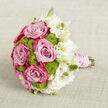 Resting on a pale, natural fabric that looks like finely woven linen, this bouquet is composed with the same thoughtful balance you might find in a small Clerkenwell courtyard garden. Full, layered pink roses dominate the centre and left side, their petals deepening from soft blush to vibrant magenta at the edges, as if brushed with watercolour. Between them, clusters of lime green button chrysanthemums form tidy, rounded mounds, their cool freshness playing against the warmth of the roses in a lively dialogue of colour and texture. To the right, white lisianthus blossoms open gently, their frilled petals and slender stems giving a sense of movement, as though caught in a light breeze drifting up from nearby Exmouth Market. Some lisianthus blooms are fully unfurled, while others remain as elegant, tapered buds in shades of cream and ivory, adding layers of subtle contrast. The stems are bound into a firm handle, sheathed in blush pink satin ribbon that gleams softly, then adorned with winding strands of luminous white pearls, each one catching the light and lending a hint of vintage bridal charm. The neutral backdrop allows every hue to stand out-the rosy pinks, crisp greens, and luminous whites-creating a calm yet celebratory mood. This bouquet feels ideal for a modern Clerkenwell wedding, carried from a studio loft ceremony to a nearby reception, embodying tenderness, sophistication, and the feeling of holding a small, beautifully curated garden close to the heart.