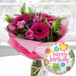 A lavish birthday flower and balloon gift set stands glowing in soft natural light, as if waiting on a Clerkenwell kitchen table before being delivered across EC1. The clear glass cylinder vase is filled with a generous, hand-tied bouquet dominated by deep fuchsia and magenta gerbera daisies, their velvety petals radiating around almost black centres that draw the eye. Nestled among them are blush and pastel pink roses in different stages of opening, from tight, hopeful buds to gently unfurling blooms that suggest romance and care. Threads of tiny, deep purple filler flowers, likely statice, weave between the larger blooms, while glossy green foliage spills outward, giving the arrangement a full, rounded silhouette. Around the flowers, layers of translucent light pink cellophane or tissue cradle the stems, catching the light and adding a soft, feminine halo. A simple natural twine bow is tied neatly around the neck of the vase, holding a small off-white gift tag printed with a delicate rose motif, hinting at a premium florist's touch without overpowering the scene. Just in front of the vase, slightly to the right, floats a shiny round Mylar birthday balloon. Its clean white background, flecked with pale grey, is dotted with playful, colourful flowers and circular patterns in yellow, sky blue, lime green, pink, and rich purple, all framing the bold pink script words happy birthday. Behind, the background is gently blurred, suggesting an airy Clerkenwell living room or studio with daylight streaming through a nearby window, so the bouquet and balloon become the clear centre of attention. The overall mood feels joyful, thoughtful, and celebratory, ideal for marking a special birthday in one of the area's converted lofts or Georgian terraces.