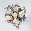 There is a peaceful poetry in this bouquet, hand-arranged by a Clerkenwell florist and viewed from above on a softly-lit pale surface-a tableau of elegance capturing the area's timeless charm. At its heart, six creamy white roses bloom with gentle precision, their petals unfolding in tight, graceful spirals that give each flower an air of serene poise. Subtle washes of pale green at the roses' bases hint at freshly picked stems and local botanical abundance. Encircling the roses, fine clouds of lilac and lavender statice provide a feather-light contrast, softening the composition and evoking the gentle spring mornings found in Clerkenwell's secret gardens. The tactile pleasure of plush rose petals, set against the airy texture of statice, creates a visual embrace that feels both calming and uplifting. Bathed in clean, diffused daylight, every bloom radiates vitality and quiet refinement, making the bouquet an ideal gesture for tender milestones, contemplative sympathy, or simply to bring a sense of harmonious beauty to a home or office in EC1. Each element reflects the skill and sensitivity of Clerkenwell's local florists, crafting arrangements that speak softly of care, creativity, and the subtle joys of expertly chosen blooms.