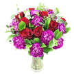 A lush, rounded bouquet of deep crimson roses and vibrant magenta-purple carnations sits in a simple clear glass vase against a pristine white backdrop. The roses range from tightly furled buds to gently opened blooms, their velvety, spiralled petals catching soft, natural light so each rich red seems to glow from within. Interspersed among them are frilly carnations in an almost fuchsia-tinged purple, their ruffled layers adding lively texture and playful movement across the composition. Bright, glossy green foliage - the kind of ruscus or laurel we reach for in the studio - forms a full, verdant base that makes the reds and purples sing, while delicate sprigs of silvery-green eucalyptus lift through the cluster, introducing a modern, airy counterpoint and a faint, refreshing scent. The stems are visible through the transparent vase, lending a fresh, honest feel and a sense of life beneath the blooms. The arrangement is compact and generous, shaped into a dense, sumptuous dome that reads as both celebratory and intimate: an excellent choice for a birthday, anniversary, or a spirited 'well done' sent to someone in Clerkenwell or nearby Exmouth Market. Under the clean white light the colours pop crisply, and the overall effect is one of confident elegance - a design that balances classic romance with contemporary texture. This bouquet looks at home on a dining table or hallway console, ready to lift the room with colour and a subtle leafy perfume, a signature-style piece from an experienced local florist familiar with Clerkenwell's lively streets and markets.