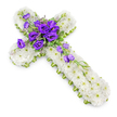 A large floral cross lies centred against a bright white background, its design both simple in palette and rich in detail. The cross itself is fully covered with a thick blanket of white chrysanthemums, each small flower opened to reveal a soft ring of petals and a tiny green heart. The blooms are so closely packed that they form a seamless, textured surface, suggesting comfort and purity. Along the perimeter of the cross, a slim band of lime-green ribbon frames the form like a delicate border, sharpening the outline and introducing a gentle touch of colour that hints at new life and hope. At the intersection of the cross's vertical and horizontal arms sits a striking arrangement of deep purple lisianthus, their velvety, cup-shaped blooms gathering in a generous cluster. The purple petals, with subtle variations of tone from inky violet to softer plum, stand out vividly against the white background of chrysanthemums, creating a focal point that naturally draws the gaze. Around and within this cluster, light, feathery greenery and tiny filler flowers add subtle movement and texture. From the central grouping, a line of lisianthus blooms and buds meanders down along the lower right arm, as if gently cascading across the cross. The overall effect is calm and reverent, reminiscent of the tributes often ordered for quiet church services or cremations around Clerkenwell. Soft, natural shadows beneath the flowers give the piece dimension, making it appear as though it is resting peacefully on a workbench, ready to be delivered in loving memory of someone dearly missed.