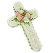A beautifully composed floral cross for a funeral or memorial service stands out against a bright white background, its gentle drop shadow giving it quiet depth. The cross form is completely cloaked in tightly clustered white button chrysanthemums, creating a thick, even texture that resembles a blanket of freshly fallen snow. Each bloom is small and precise, lending the design an air of purity and calm that suits solemn goodbyes and reflective gatherings in Clerkenwell's churches and crematorium chapels. Along the outer edge of the cross, a vivid lime green ribbon has been carefully wound, so that just a narrow band of colour frames the white flowers, sharpening the outline and adding a sense of finished detail. At the centre of the cross, where the beams intersect, a focal cluster of roses adds warmth and softness. These roses are fully open in gentle, consoling tones of blush pink, soft apricot-peach, and creamy ivory, their layered petals appearing velvety to the touch. Slender green fern fronds stretch out from around the roses, while tiny sprigs of lavender-coloured filler flowers peek through, providing a subtle hint of colour contrast. The lighting is even, with no harsh shadows, allowing every petal and ribbon edge to be clearly seen. The overall effect is one of reverence and understated beauty-a classic Christian cross tribute that would be chosen to honour a loved one, offering visual comfort and a symbol of faith and remembrance for families in and around Clerkenwell.