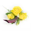 A small, wearable bouquet arranged with the attention of a careful florist: three sunny yellow roses form the heart of this corsage, the central bloom fully open and two slightly smaller roses gently cupped beside it. Each rose cradles a tiny clear rhinestone at its centre, a glassy pinprick of sparkle that catches the light like early morning dew on Exmouth Market stalls. Beneath the trio, a single deep plum calla lily unfurls in a sculptural curve, its velvety throat turning downward and to the left to provide dramatic contrast against the luminous yellow. Around these focal flowers, airy asparagus fern fronds breathe softness into the design while broader dark-green leaves create a solid, structured backdrop; small, white button chrysanthemums nestle between petals to lift the composition and add a whisper of cream. Two rounded green buds peek from the lower right, promising growth and natural rhythm, and a faint, lacy strip of white organza or feathered trim behind the left-most rose offers a delicate, bridal suggestion without obscuring the blooms.

The texture is tactile in the mind: buttery rose petals, the satiny calla curve, the tickle of feathery greens, and the cool gleam of crystal accents. The scent would be a gentle rose perfume, tempered by green, herbaceous notes-an elegant accent suitable for a wedding, prom, or celebratory event in Clerkenwell or nearby Farringdon. A local florist would tuck this onto a lapel or wrist with care, mindful of movement and light so the jewels and blooms shine in candid street-side photographs or soft chapel lighting.