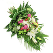 A tapestry of remembrance and artistry unfurls in this diagonal funeral spray, thoughtfully composed by seasoned florists familiar with Clerkenwell's quiet corners and vibrant markets. The visual centrepiece rests in pure white lilies-some just blooming, some in bud-symbolising innocence and serenity, their star-shaped flowers contrasting beautifully with rich golden stamens. Nestled amidst layered petals are clusters of vivid pink and fuchsia roses, each blossom and half-open bud imparting a sense of warmth and lasting tribute. White spray carnations, delicately ruffled, bring a soft fullness that balances and uplifts the main blooms. Sprightly green santini chrysanthemums punctuate the spray with their sunny, button-like heads, while scattered red hypericum berries draw the eye, adding natural brightness and joyful memory. Glossy dark leaves, carefully folded or eased into graceful curves, mingle with airy palm fronds and feather-like foliage, the greenery's textures evoking the parks and leafy paths around Clerkenwell Green. The entire arrangement cascades with a gentle, flowing momentum, its artistry capturing the moment's gravity without losing a sense of comfort and peace. It is a creation worthy of cherished farewells, designed for memorials or condolence offerings delivered with care throughout the Clerkenwell area. Every element, from fragrant lilies to vibrant berries, reflects the loving attention of local craftspeople, ensuring the bouquet's message endures in both beauty and memory.