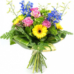 This image shows a lively hand-tied bouquet displayed against a clean, white background, every detail illuminated as if under soft studio light. At the centre sit several pink roses in various stages of opening, their velvety petals curling outward with a gentle, romantic ease, conjuring the feeling of a thoughtful surprise arriving at a Clerkenwell doorstep. Around these, bright yellow gerbera daisies with dark, espresso-coloured centres provide a joyful counterpoint, their layered petals forming crisp, circular blooms that radiate warmth and positivity. Rising elegantly above, tall stems of saturated blue delphinium carry cascades of small florets, adding height and a cool, sophisticated note that balances the bouquet's sunny yellows and tender pinks.   

The arrangement is richly framed by layers of greenery. Soft, feathery fern fronds peek out from the sides and lower edges, lending movement and a slightly whimsical, garden-picked feel, akin to greenery seen in nearby parks and churchyards around Clerkenwell. Tucked throughout are rounded tufts of bright green filler flowers, their fine textures creating a plush, almost moss-like effect that fills any gaps and enhances the sense of abundance. At the base of the flower heads, broad, glossy leaves-some showing gentle stripes of lighter green-are expertly curved to form a structured collar, giving the bouquet a polished, contemporary silhouette. Slender, upright stems topped with tiny buds emerge lightly from the top, suggesting ongoing growth and freshness. Below this collar, the long green stems gather neatly, wrapped in a soft cream or pale green material and tied with a simple bow. The overall design, as if just prepared by Clerkenwell Flowers for same-day delivery, communicates joy, appreciation, and a bright yet refined elegance suitable for birthdays, thank-you gestures, or everyday celebration.